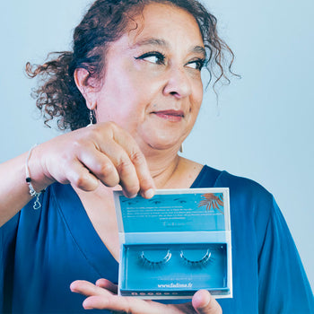 La grâce mûre incarnée : une beauté mate de plus de 50 ans, son regard délicatement tourné. Elle présente les Faux cils Harmonieux de Fadime, naturels en fibres de chanvre 100% végétales et biodégradables. Végan, doux, durables, d'une qualité exquise. Hypoallergéniques et sans paraben, ils conviennent aux yeux sensibles. Leur épaisseur et leurs bandes transparentes en fibres de coton offrent un confort flexible et une tenue parfaite. Réutilisables jusqu'à 40 fois. La beauté responsable à son apogée.