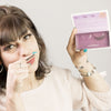 Une superbe femme de 30 ans, brune, affiche une bouche fermée. Dans sa main droite, le faux cil est collé sur son doigt, porté sur sa bouche comme une moustache, créant une touche très drôle. Son regard est mis en valeur par les faux cils naturels effet Intense FADIME en fibres de chanvre 100% végétales et biodégradables. Végan, doux et durables, Faciles à appliquer, hypoallergéniques, yeux sensibles. Réutilisables 40 fois, tenue parfaite grâce à leurs bandes transparentes en fibres de coton flexibles.