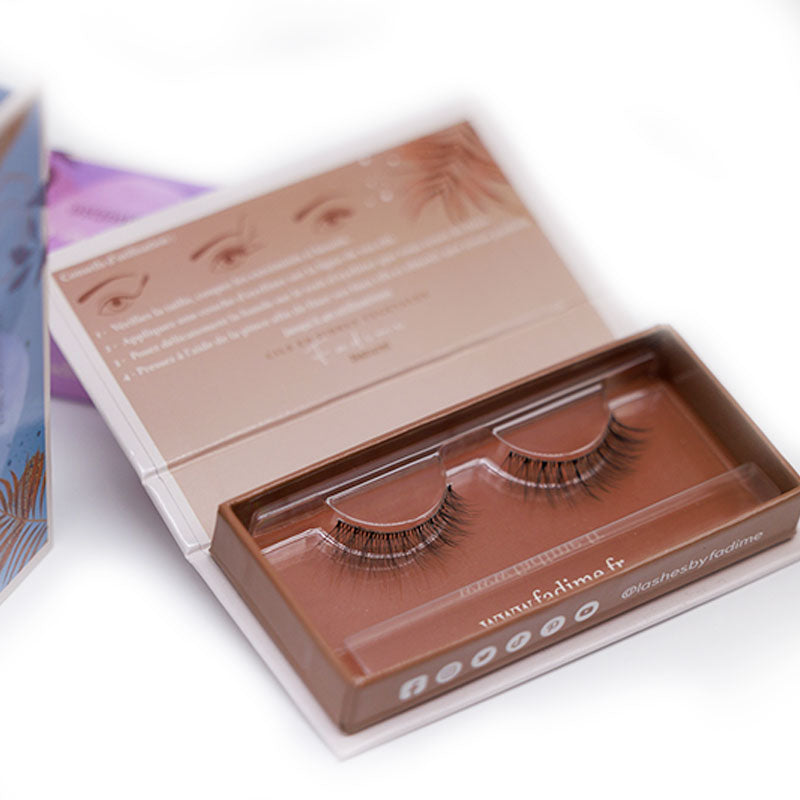 3 boites de Faux cils naturelsavec un gros plans sur la boite  effet naturel par Fadime en fibres de chanvre 100% végétales et biodégradables, fusionnant le Végan, la douceur durable et la haute qualité. Simples à appliquer, hypoallergéniques, pour yeux sensibles. Réutilisables 40 fois, ces cils épais, aux bandes transparentes en fibres de coton, offrent confort et tenue parfaite. Redéfinissez votre regard, comblez vos cils avec aisance, sans paraben. éco-responsable et élégante.